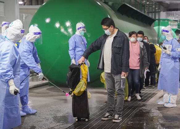 (220414) -- SHANGHAI, April 14, 2022 -- A medical worker disinfects the luggage of a COVID-19 patient before he leaves the National Exhibition and Convention Center (NECC), the largest makeshift hospital, in east China s Shanghai, April 14, 2022. A total of 322 COVID-19 patients were released from medical observation and left the NECC on Thursday morning, local authorities said. They were the first batch of patients discharged from the NECC since it started admitting COVID-19 mild cases and asymptomatic carriers on April 9, according to the municipal epidemic control office. The convention center-turned makeshift hospital has a capacity to accommodate more than 50,000 beds. ) CHINA-SHANGHAI-MAKESHIFT HOSPITAL-COVID-19 PATIENTS-RELEAS 