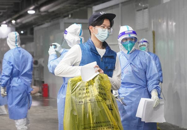 (220414) -- SHANGHAI, April 14, 2022 -- A COVID-19 patient leaves the National Exhibition and Convention Center (NECC), the largest makeshift hospital, in east China s Shanghai, April 14, 2022. A total of 322 COVID-19 patients were released from medical observation and left the NECC on Thursday morning, local authorities said. They were the first batch of patients discharged from the NECC since it started admitting COVID-19 mild cases and asymptomatic carriers on April 9, according to the municipal epidemic control office. The convention center-turned makeshift hospital has a capacity to accommodate more than 50,000 beds. ) CHINA-SHANGHAI-MAKESHIFT HOSPITAL-COVID-19 PATIENTS-RELEASE(CN) DingxTing 