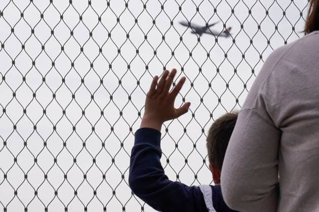 Symbolbild Abschied am Flughafen Symbolfoto Junge winkt hinter Absperrgitter dem Flugzeug hinterher Deutschland *** Symbol image farewell at the airport symbol photo boy waving behind barrier fence after the plane Germany