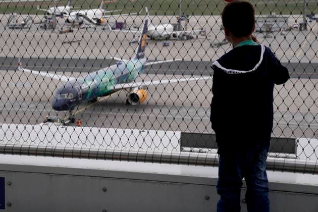 Symbolbild Sehnsucht Flughafen Symbolfoto Junge sieht Flugzeug bei der Abfertigung und Vorbereitung auf den Abflug getrennt durch ein Gitter zu. Deutschland *** Symbol image longing airport symbol photo boy sees plane checking in and preparing for departure separated by a grid to Germany