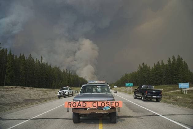 Forest fire, controlled burn adjacent to road, Road Closed sign on pickup truck, Saskatchewan Valley, Banff N P Rocky Mountains, Alberta, Canada, June 2009, North America. Copyright: imageBROKER/FLPAx/xBillxCoster iblhoj05627053.jpg