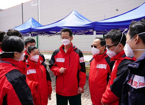 (220415) -- SHANGHAI, April 15, 2022 -- Medical workers from Huashan Hospital of Fudan University communicate at a makeshift hospital in Lingang of Shanghai, east China, April 15, 2022. Medical workers serving at the makeshift hospital in Lingang are from different places including Shanghai, and neighboring Jiangsu and Zhejiang Provinces. ) CHINA-SHANGHAI-MAKESHIFT HOSPITAL (CN) YangxYouzong 