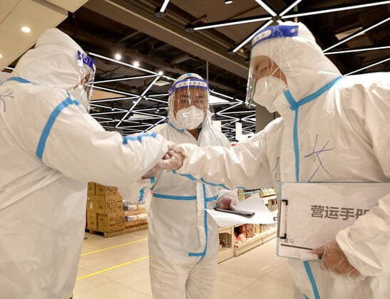 (220415) -- SHANGHAI, April 15, 2022 -- Du Shun (C), deputy manager of a Hema Fresh store in Wuhan, and Yuan Liang (R), manager of a Hema Fresh store in Shanghai, cheer for each other at a store in Shanghai, east China, April 15, 2022. Recently, Hema Fresh, a Chinese fresh items supermarket, has organized aid teams from more than 20 cities including Beijing, Chengdu, Xi an, Hefei and Wuhan to support Shanghai in the delivery of living supplies. Du Shun, deputy manager of a Hema Fresh store in Wuhan, central China s Hubei Province, led a team to assist in the supply guarantee work in a Hema Fresh store in Shanghai from April 12. Du said that in 2020 he once witnessed the great contribution made by the Shanghai medical team to the epidem