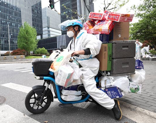 (220415) -- SHANGHAI, April 15, 2022 -- Liu Zengyu, a delivery man from Jiangxi Province, delivers goods in Shanghai, east China, April 15, 2022. Recently, Hema Fresh, a Chinese fresh items supermarket, has organized aid teams from more than 20 cities including Beijing, Chengdu, Xi an, Hefei and Wuhan to support Shanghai in the delivery of living supplies. Du Shun, deputy manager of a Hema Fresh store in Wuhan, central China s Hubei Province, led a team to assist in the supply guarantee work in a Hema Fresh store in Shanghai from April 12. Du said that in 2020 he once witnessed the great contribution made by the Shanghai medical team to the epidemic control work in Wuhan. As a new outbreak occurred in Shanghai, Du applied for the a