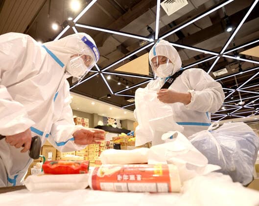 (220415) -- SHANGHAI, April 15, 2022 -- Zhang Jing (R), a staff member from Wuhan, packs up goods with her colleague at a Hema Fresh store in Shanghai, east China, April 15, 2022. Recently, Hema Fresh, a Chinese fresh items supermarket, has organized aid teams from more than 20 cities including Beijing, Chengdu, Xi an, Hefei and Wuhan to support Shanghai in the delivery of living supplies. Du Shun, deputy manager of a Hema Fresh store in Wuhan, central China s Hubei Province, led a team to assist in the supply guarantee work in a Hema Fresh store in Shanghai from April 12. Du said that in 2020 he once witnessed the great contribution made by the Shanghai medical team to the epidemic control work in Wuhan. As a new outbreak occurred