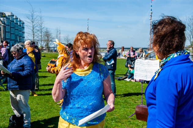 April 16, 2022, Nijmegen, Gelderland, Netherlands: A woman wearing the colors of the Ukrainian flag is seen singing the national anthem. Under the motto, music connects people , the Nijmegen musician Mart Heijmans brought together 400 musicians at the Waalkade to sing the Ukrainian national anthem and other songs to show their solidarity with Ukraine. Around 250 of them were Ukrainian refugees received during the last months in the city. Four Ukrainian singers who have fled, including an opera singer, performed a few more songs before an attentive and emotional crowd. Nijmegen Netherlands - ZUMAs197 20220416_zaa_s197_050 Copyright: xAnaxFernandezx