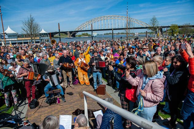 April 16, 2022, Nijmegen, Gelderland, Netherlands: People are seen taking photos of the musicians singing the Ukrainian national anthem. Under the motto, music connects people , the Nijmegen musician Mart Heijmans brought together 400 musicians at the Waalkade to sing the Ukrainian national anthem and other songs to show their solidarity with Ukraine. Around 250 of them were Ukrainian refugees received during the last months in the city. Four Ukrainian singers who have fled, including an opera singer, performed a few more songs before an attentive and emotional crowd. Nijmegen Netherlands - ZUMAs197 20220416_zaa_s197_060 Copyright: xAnaxFernandezx