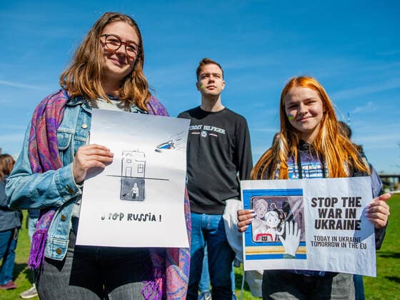 April 16, 2022, Nijmegen, Gelderland, Netherlands: Two women are seen holding placards in support of Ukraine. Under the motto, music connects people , the Nijmegen musician Mart Heijmans brought together 400 musicians at the Waalkade to sing the Ukrainian national anthem and other songs to show their solidarity with Ukraine. Around 250 of them were Ukrainian refugees received during the last months in the city. Four Ukrainian singers who have fled, including an opera singer, performed a few more songs before an attentive and emotional crowd. Nijmegen Netherlands - ZUMAs197 20220416_zaa_s197_062 Copyright: xAnaxFernandezx