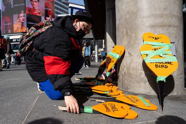 April 18, 2022, Toronto, ON, Canada: A demonstrator picks up an orange heart shaped sign printed with the name of a residential school victim as Indigenous activists and supporters rally at Yonge and Dundas Square in Toronto on Monday, April 18, 2022. Toronto Canada  - ZUMAc35_ 20220418_zaf_c35_002 Copyright: xYaderxGuzmanx