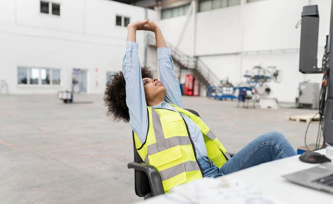 Engineer stretching hands sitting on chair in factory model released, Symbolfoto property released, JCCMF05791