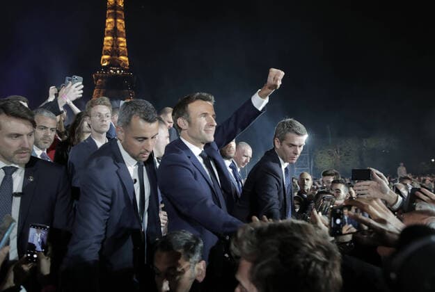 Supporters cheer on Emmanuel Macron after he was re-elected as France s president on the Champ de Mars in front of the Eiffel Tower in Paris, France, on Sunday April 24, 2022. Citizens went to the polls today to choose between far-right candidate Marine Le Pen and Macron.  PAR20220424216 MAYAxVIDON-WHITE