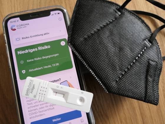 Risiko-Ermittlung Corona auf dem Handy mit Corona Warn-App *** Risk detection Corona on cell phone with Corona Warn App 1088813965