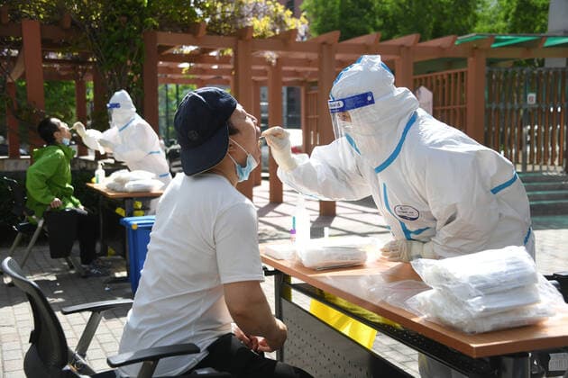 (220426) -- BEIJING, April 26, 2022 -- A medical worker takes a swab sample from a citizen at a makeshift nucleic acid testing site during a mass testing for COVID-19 in Haidian District, Beijing, capital of China, April 26, 2022. Beijing will conduct three rounds of nucleic acid testing in 11 areas from Tuesday to Saturday in efforts to curb the risk of COVID-19, local authorities said at a press conference Monday. The testing will cover people in the districts of Xicheng, Dongcheng, Haidian, Fengtai, Shijingshan, Fangshan, Tongzhou, Shunyi, Changping, Daxing and Beijing Economic-Technological Development Area, said Xu Hejian, spokesperson of the municipal government of Beijing. ) CHINA-BEIJING-COVID-19-NUCLEIC ACID TEST-EXPANSION (C