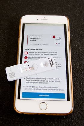 Bamberg, Germany 28 April 2022 Topic Images Symbol Images Coronavirus 2022 On a table is an antigen rapid test for the coronavirus SARS CoV 2 this shows the result positive, next to it is a cell phone with the message that the result of the PCR test result is also positive Bavaria Copyright: xFotostandx xK.xSchmittx