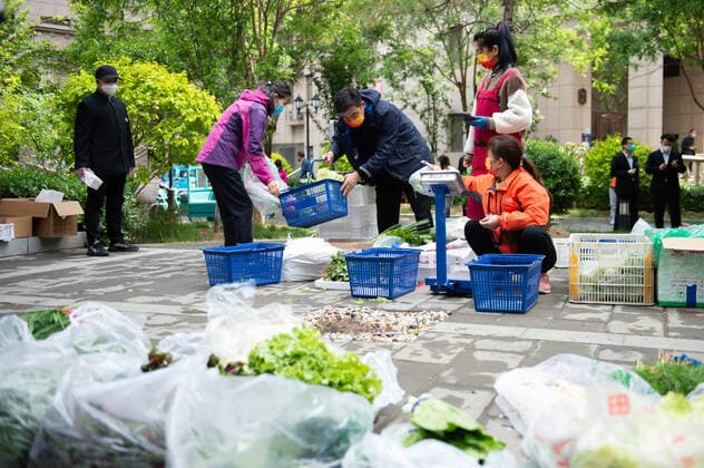 (220428) -- BEIJING, April 28, 2022 -- A resident (2nd L) buys vegetables at a temporary stand selling daily necessities in a community in Chaoyang District of Beijing, capital of China, April 28, 2022. During the latest resurgence of COVID-19 infections in Beijing, people from different walks of life have joined the fight against the coronavirus, working against the clock to offer hearty support. ) CHINA-BEIJING-COVID-19 (CN) ChenxZhonghao 