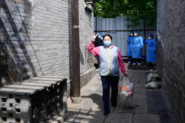 (220428) -- BEIJING, April 28, 2022 -- A resident poses for a photo with a parcel she picked in a community in Dongcheng District of Beijing, capital of China, April 28, 2022. During the latest resurgence of COVID-19 infections in Beijing, people from different walks of life have joined the fight against the coronavirus, working against the clock to offer hearty support. ) CHINA-BEIJING-COVID-19 (CN) ZhangxChenlin 