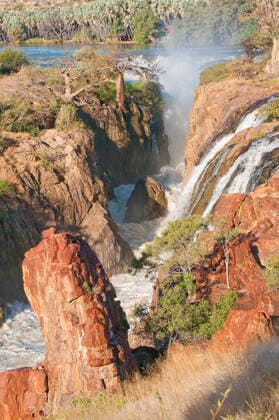 Creative Highlights World A small portion of the Epupa waterfalls in on the border of Angola and Namibia , 14610378.jpg, Epupa, waterfall, falls, namibia, water, cascade, rapids, Baobab, tree, rocks, cliffs, flood, dangerous, africa, african, nature, boulders, dramatic, landscape, gorge, kaokoland, kaokoveld, kunene, river, palm, makalani palm, palm trees, landscape, red,