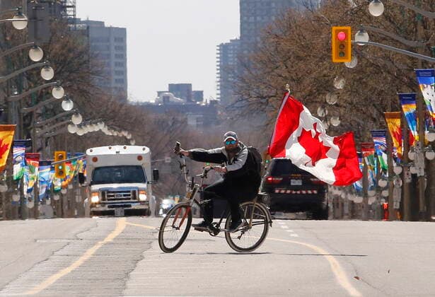 April 29, 2022, Ottawa, ON, Canada: A man rides a bicycle on Wellington Street before the arrival of the Rolling Thunder motorcycle convoy protest in Ottawa on Friday, April 29, 2022. Ottawa Canada  - ZUMAc35_ 20220429_zaf_c35_072 Copyright: xPatrickxDoylex