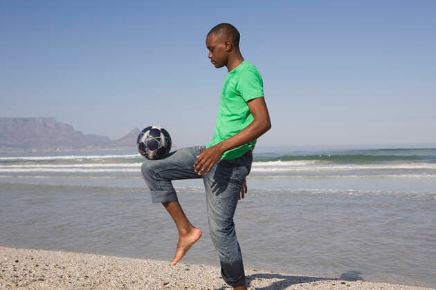 Young Man Playing Soccer On Beach, model released, , 10116040.jpg, Activity, Adult, African, American, Balance, Bald, Ball, Barefoot, Beach, Black, Blue, Casual, Coastline, Concentration, Copyspace, Denim, Exercise, Foot, Football, Green, Horizontal, Jeans, Keepy Uppy, Leisure, Man, Mountain, Nature, Ocean, One, Outdoors, Person, Playing, Practising, Profile, Recreation, Sand, Sea, Shore, Side View, Sky, Soccer, South Africa, Sport, Standing, Summer, Sunny, Training, Tshirt, Young, 30s,