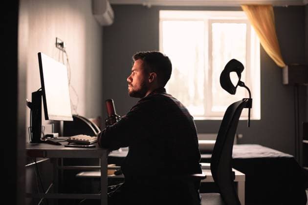 Man sitting at desk working on computer at home New York, New York, United States CR_DMBE211029-834988-01 ,model released, Symbolfoto