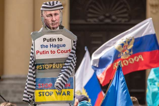 News Bilder des Tages Prorussische Demonstration auf dem Odeonsplatz gegen Diskriminierung, zeitgleich Gegendemonstration von Unterstützern der Ukraine mit Putin als Pappfigur (vorn), München, 09. Mai 2022 DEU, Deutschland, Muenchen, 9. Mai 2022, Gegendemonstration (hier im Vordergrund) gegen Russland-Unterstützer und Putins Krieg in der Ukraine, Pappfigur Putin in Sträflingskleidung mit Schrift Putin to the Hague, Forderung Putin als Kriegsverbrecher in Den Haag vor Gericht zu stellen, ca. 100 Teilnehmer, zeitgleich: Prorussische Demonstration unter dem Titel Diskriminierung gegen russischsprachige Leute, auf dem Odeonsplatz (Demo hier im Hintergrund) mit grosser russischer Flagge, ab 14 Uhr, ca. 200 Teilnehmer, Russen in München demonstrierier