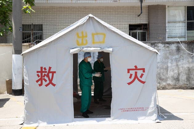 (220510) -- SHANGHAI, May 10, 2022 -- Meng Xiangjun (L) and Zhang Zhimin conduct disinfection after taking off protective suits near the headquarters of a medical emergency team in east China s Shanghai, May 9, 2022. A medical emergency team consisting of 108 members with 50 ambulances from north China s Tianjin has arrived at Shanghai to assist in the city s public medical emergency service amid the COVID-19 resurgence. ) CHINA-SHANGHAI-MEDICAL TEAM-COVID-19-AID (CN) JinxLiwang 