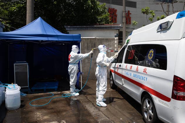 (220510) -- SHANGHAI, May 10, 2022 -- Meng Xiangjun (L) and Zhang Zhimin disinfect an ambulance near the headquarters of a medical emergency team in east China s Shanghai, May 9, 2022. A medical emergency team consisting of 108 members with 50 ambulances from north China s Tianjin has arrived at Shanghai to assist in the city s public medical emergency service amid the COVID-19 resurgence. ) CHINA-SHANGHAI-MEDICAL TEAM-COVID-19-AID (CN) JinxLiwang 