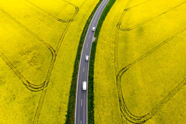 IMAGO Nature: Unsere Erde, Energiequellen, Biomasse Strasse im Rapsfeld Nauen, 20.02.2022 - Luftbild von Autos auf einer Strasse in Rapsfeldern. Nauen Brandenburg Deutschland *** Road in rape field Nauen, 20 02 2022 aerial view of cars on road in rape field Nauen Brandenburg Germany