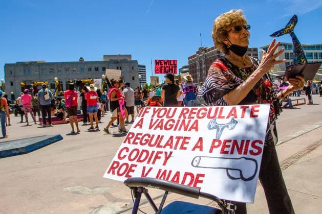 May 14, 2022, Reno, Nevada, United States: (Editors note image depicts profanity).A protester walks past a placard at a pro abortion rights rally. People gathered to voice their displeasure with the supreme courts leaked document that likely signals the over turn of Roe v Wade. Reno United States - ZUMAs197 20220514_zaa_s197_493 Copyright: xTyxONeilx