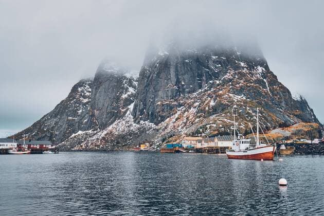 IMAGO Creative, Unsere Erde, Umweltverträgliche Herausforderungen des 21. Jahrhunderts, Überfischung Ein Fischerboot im Fischerdorf Hamnoy auf den Lofoten, Norwegen, mit roten Rorbu-Häusern. Mit fallendem Schnee, Europa *** A fishing boat in the fishing village of Hamnoy in Lofoten, Norway, with red rorbu houses With falling snow, Europe Copyright: imageBROKER/DmitryxRukhlenko ibxdmr08292965.jpg