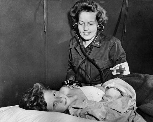U.S. Army nurse attends wounded French child in Normandy (France), summer 1944 A U.S. Army Lieutenant nurse takes blood pressure of a French child wouded by a German mine explosion in Normandy (France), summer 1944 Copyright: xPhoto12 Coll-DITE USISx DIT01079_028