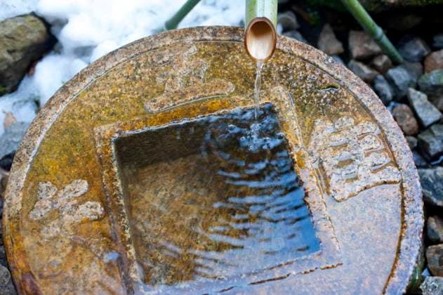 Close up on traditional ritual washing basin at the Ryoan-Ji Tsukubai temple in Japan , 24970998.jpg, buddhist, kakei, kyoto, pipe, ryan-ji, stone, wash, water, bamboo, purify, religion, ritual, running, traditional, visitors, japan, japanese, temple, purification, spiritual,