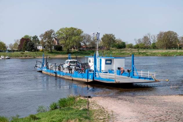 Barby Saxony Anhalt Germany April 2022 Gierseilfähre Barby motorless reaction ferry crossing the River Elbe. A reaction ferry uses the motion of the current of the water going back and forth like a pendulum attached by wires to an anchor point further upstream. Barby Sachsen Anhalt Deutschland April 2022 Gierseilfähre Barby über die Elbe. Eine Gierseilfähre nutzt die Bewegung des hin- und hergehenden Wasserstroms wie ein Pendel, das mit Drähten an einem weiter stromaufwärts gelegenen Ankerpunkt befestigt ist.