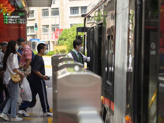 (220522) -- SHANGHAI, May 22, 2022 -- Passengers get on a bus in Shanghai, east China, May 22, 2022. Shanghai started to resume cross-district public transport starting from Sunday. Transport service on four subway lines and 273 bus routes has resumed on Sunday covering the central urban areas and the city s airports, railway stations, and hospitals. Passengers are allowed to use the public transport system only when they have negative result certificates for nucleic acid testing taken within 48 hours. ) CHINA-SHANGHAI-PUBLIC TRANSPORTATION-RESUMPTION (CN) LixHe 