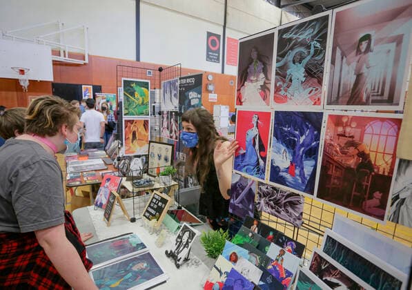 (220522) -- VANCOUVER, May 22, 2022 -- A comic artist speaks with visitors at her booth during the Vancouver Comic Art Festival in Vancouver, British Columbia, Canada, on May 22, 2022. The Vancouver Comic Art Festival, an annual celebration of comics and graphic novels and their creators, features over one hundred of comic creators from around the world this year. (Photo by Xinhua) CANADA-VANCOUVER-COMIC ART FESTIVAL LiangxSen 