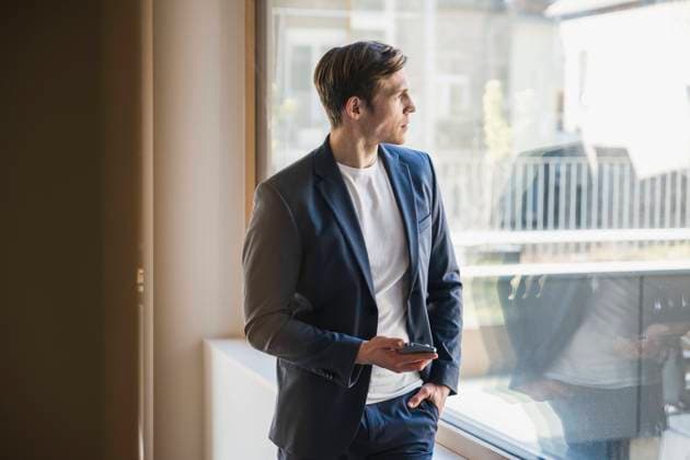 Businessman looking out of window in office model released, Symbolfoto property released, UUF25767
