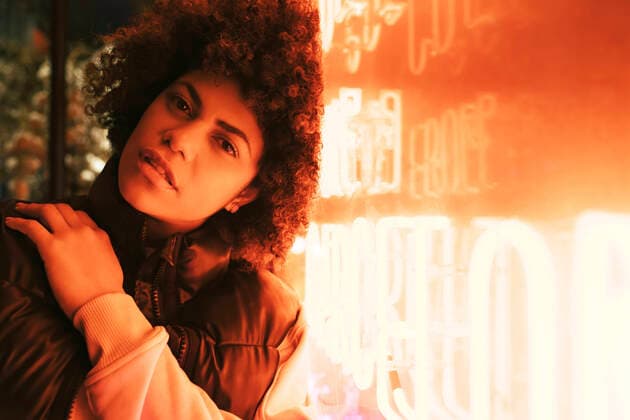Creative Highlights Symbolbilder Young beautiful woman with Afro hairstyle leaning on illuminated wall model released, Symbolfoto, MMPF00031
