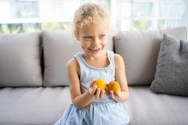 Happy girl with Easter eggs sitting on sofa at home model released, Symbolfoto property released, SVKF00145