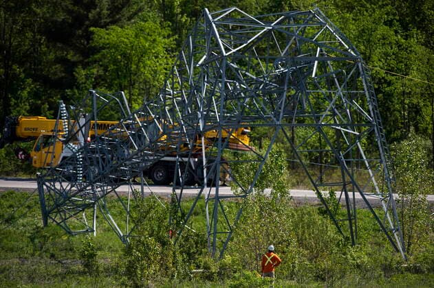 May 24, 2022, Ottawa, ON, CAN: A utility worker assesses a transmission tower as they work to sever it from its base to remove it, after it was damaged in SaturdayöÄÃ s major storm in Ottawa, on Tuesday, May 24, 2022. Ottawa CAN  - ZUMAc35_ 20220524_zaf_c35_035 Copyright: xJustinxTangx