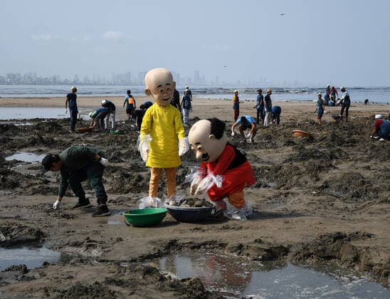 June 5, 2022, Mumbai, Maharashtra, India: Nicktoons Motu (R) and Patlu (L) (Fat and Thin) are seen putting the waste collected in a waste carrying bucket. Beach clean up drive was carried out at Versova beach on the occasion of World Environment day to appeal beachgoers to use dustbins to throw plastic covers, bottles and other waste. Mumbai India - ZUMAs197 20220605_zaa_s197_267 Copyright: xAshishxVaishnavx
