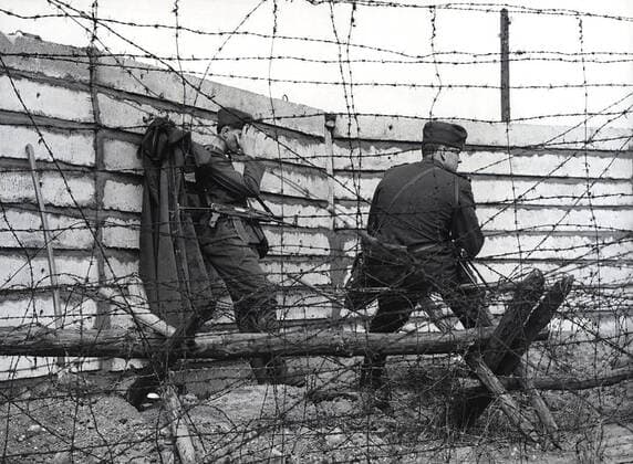 East German soldiers in front of largest wall built so far - The work crews erected five meters behind the old, dilapidated and partly collapsed wall, a concrete slab new, stable wall of a meter wide, with cement poured out. It has the high of 2.50 meters, making it the highest wall, there is. 06 28 1962 1062_05_M_-12877-