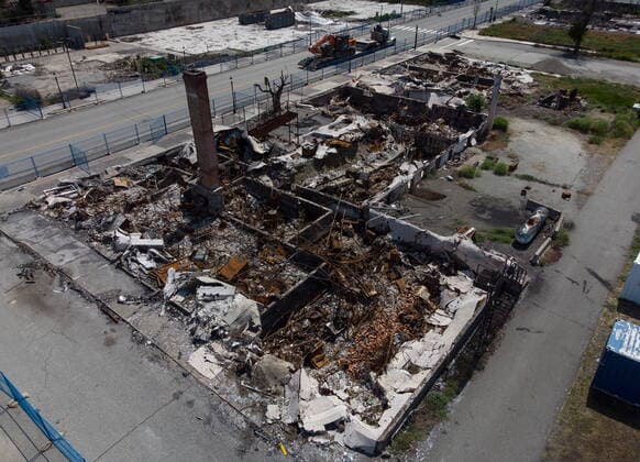 June 14, 2022, LYTTON, BC, CANADA: Heavy equipment used to clear debris is transported on Main Street past a hotel that was destroyed by wildfire in Lytton, B.C., on Tuesday, June 14, 2022. The fire-ravaged community of Lytton, B.C., will get $77 million from the federal government to help it rebuild a fire-resistant and energy-efficient community. Two people were killed and much of the centre of the village was destroyed when wildfire ripped through the community almost a year ago. LYTTON CANADA  - ZUMAc35_ 20220614_zaf_c35_085 Copyright: xDarrylxDyckx