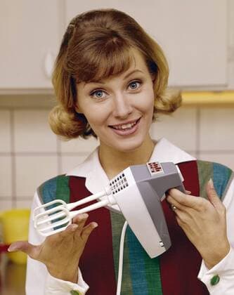 In the 1960s. A young woman pictured in the kitchen using an electric hand mixer. Copyright: xClassicxPicturexLibraryx