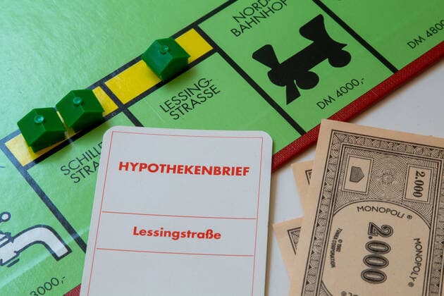 Symbolbild Immobilienblase: Monopolyspiel mit Hypothekenbrief *** Symbol image real estate bubble monopoly game with mortgage note Copyright: xx