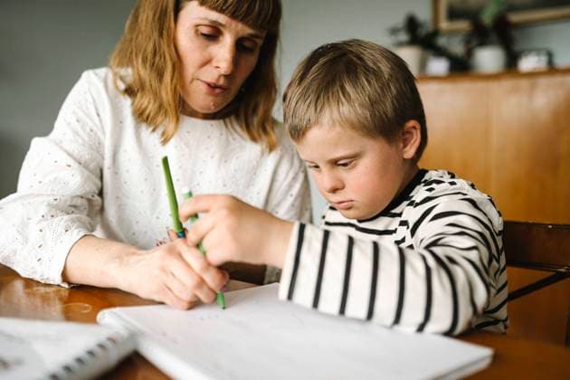 IMAGO Creative: Mutterschaft IMAGO Kreativ: Bildung, Kunsterziehung Boy with disability taking support of mother while drawing in book at home Sweden, Gothenburg, model released, property released Copyright: xMaskotx , MA93746