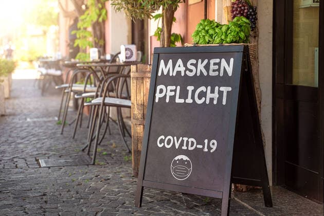 20 June 2022: Sign in front of the entrance of a restaurant or store with the inscription Mask obligation, obligation to wear a medical protective mask, mouth-nose protection PHOTOMONTAGE