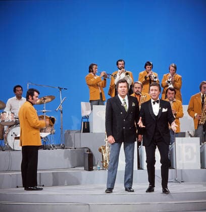 DREI MAL NEUN Drei mal Neun, ZDF Quizshow, Deutschland, 1971, im Bild: Bandleader Max Greger mit Bigband, Showmaster Wim Thoelke und Showgast Peter Alexander bei einer heiteren Showdarbietung. Drei mal Neun, TV quiz show, Germany, 1971, on the photo: Bandleader Max Greger with big band, presenter Wim Thoelke and show guest Peter Alexander with a cheerful show performance., Deutschland Copyright: ArthurxGrimm UnitedArchives82007882 EDITORIAL USE ONLY