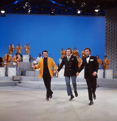 DREI MAL NEUN Drei mal Neun, ZDF Quizshow, Deutschland, 1971, im Bild: Bandleader Max Greger mit Bigband, Showmaster Wim Thoelke und Showgast Peter Alexander bei einer heiteren Showdarbietung. Drei mal Neun, TV quiz show, Germany, 1971, on the photo: Bandleader Max Greger with Big band, presenter Wim Thoelke and show guest Peter Alexander with a cheerful show performance., Deutschland Copyright: ArthurxGrimm UnitedArchives82007884 EDITORIAL USE ONLY