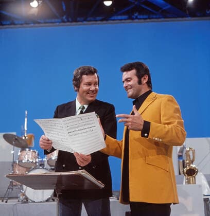 DREI MAL NEUN Drei mal Neun, ZDF Quizshow, Deutschland, 1971, im Bild: Showmaster Wim Thoelke mit Bandleader Max Greger. Drei mal Neun, TV quiz show, Germany, 1971, on the photo: presenter Wim Thoelke with Max Greger., Deutschland Copyright: ArthurxGrimm UnitedArchives82007919 EDITORIAL USE ONLY