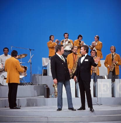 DREI MAL NEUN Drei mal Neun, ZDF Quizshow, Deutschland, 1971, im Bild: Showmaster Wim Thoelke mit Showgast Peter Alexander und Max Greger Bigband. Drei mal Neun, TV quiz show, Germany, 1971, on the photo: presenter Wim Thoelke with show guest Peter Alexander and Max Greger Big band., Deutschland Copyright: ArthurxGrimm UnitedArchives82007929 EDITORIAL USE ONLY